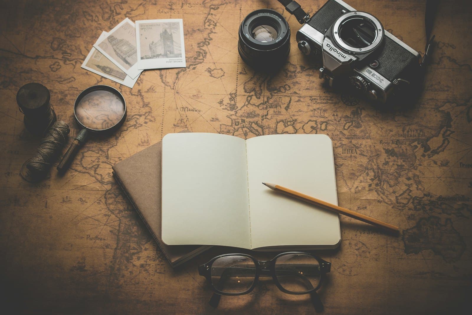 An open notebook and a cup on a wooden table