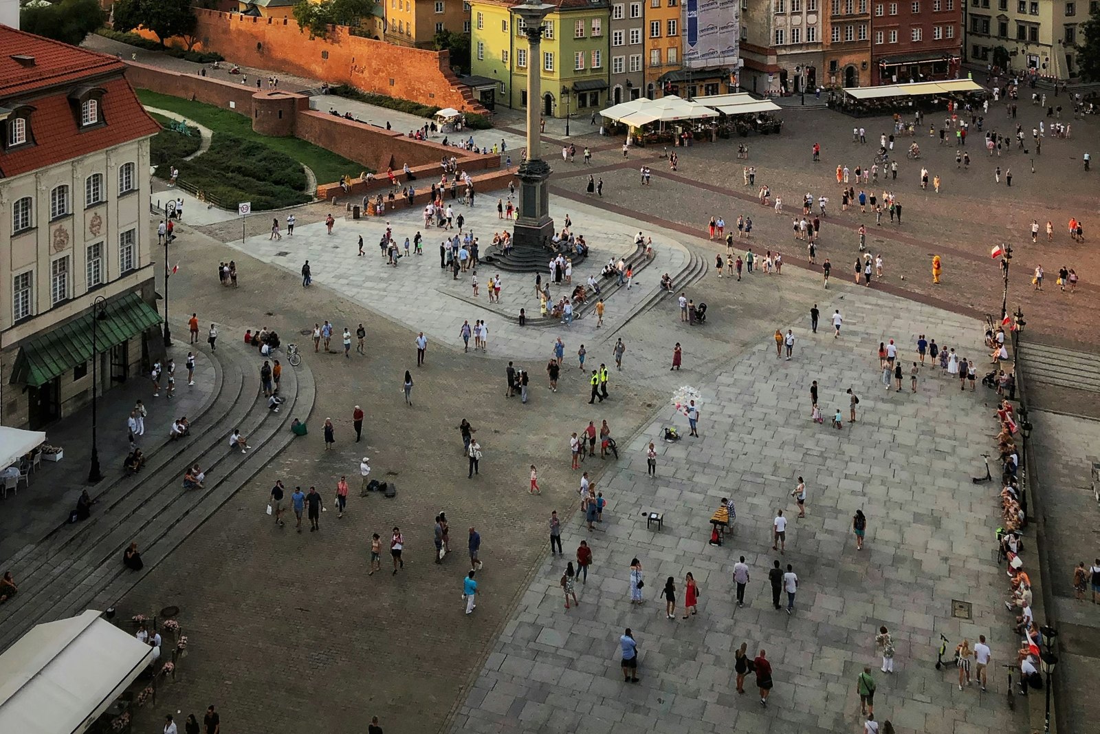 A pedestrian square seen from above, with people walking and sitting without hurry